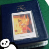 A dark blue compact photo album with a gold embossed title and an open view of instant film photos inside.