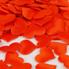 Orange heart-shaped sponge confetti scattered on a white surface for weddings and celebrations