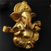 Golden handcrafted statue of Ganesha with an elephant head and decorative crown