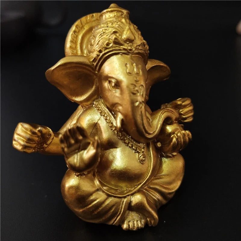 Golden handcrafted statue of Ganesha with an elephant head and decorative crown