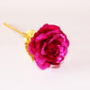 A deep magenta artificial rose with a gold foil stem against a white background.