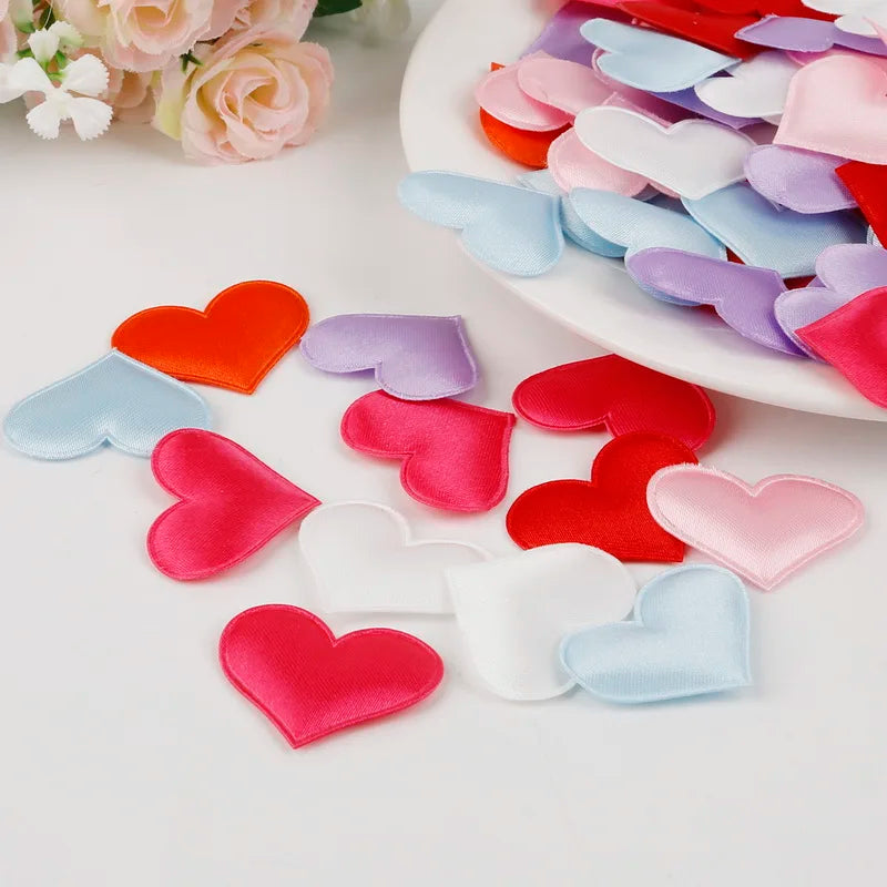 A collection of heart-shaped sponge confetti in various pastel colors like pink, purple, blue, and red arranged on a white pl