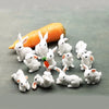 A collection of small white rabbit figurines with carrots, displayed next to a whole carrot.