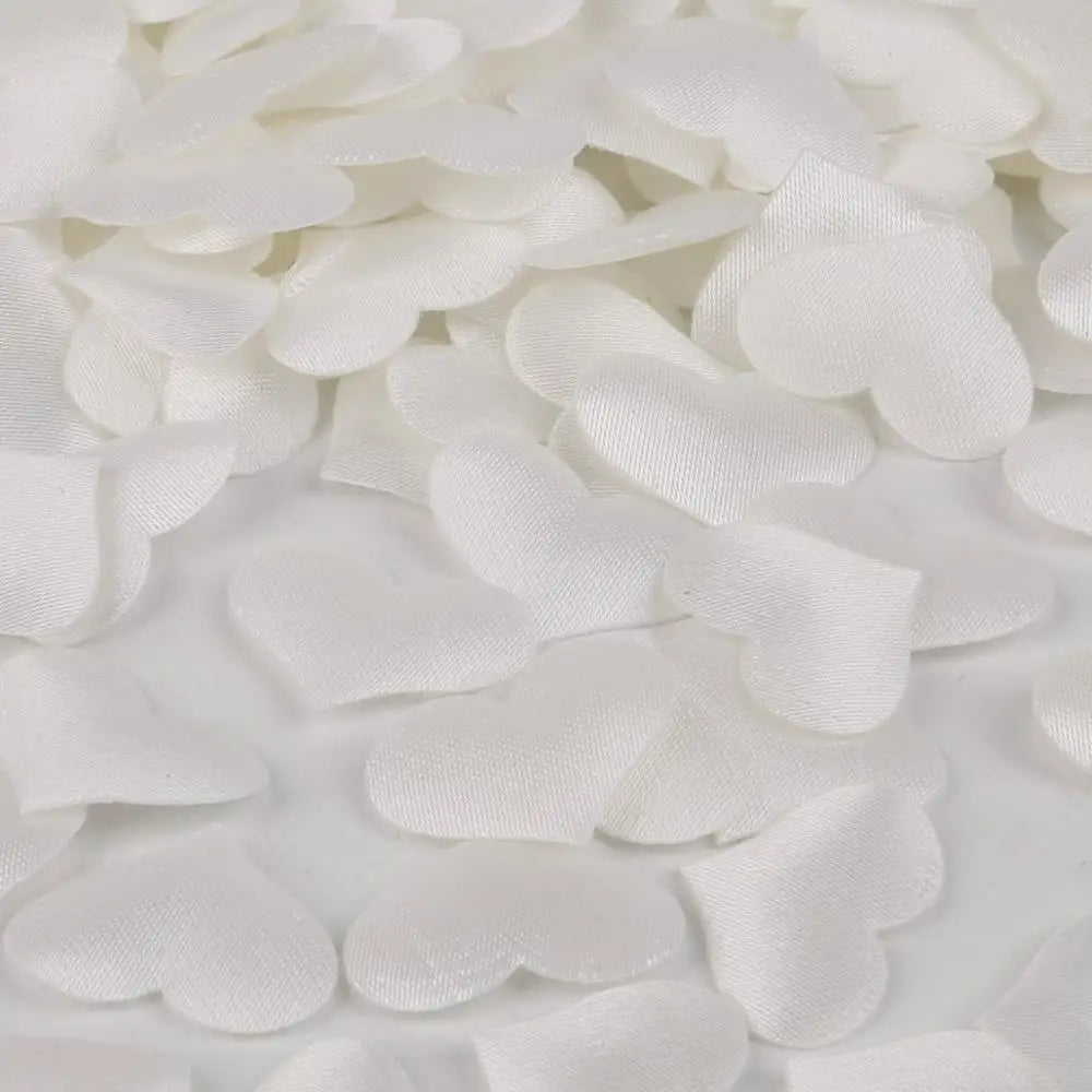 White heart-shaped sponge confetti scattered on a white surface.