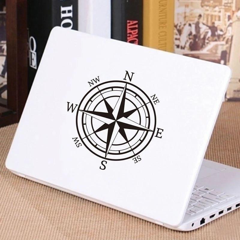 A white laptop featuring a black nautical compass rose design on the lid.