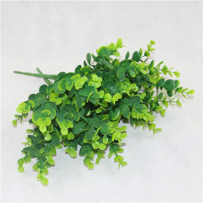 A cluster of bright green artificial fern and leaf sprigs for home decor.