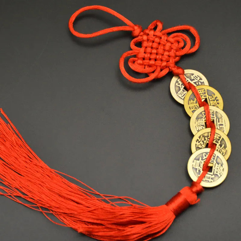 Orange thread charm with a handwoven knot and several copper coins for Feng Shui