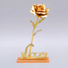 A gold foil artificial rose bouquet mounted on a stand, featuring the word Love.