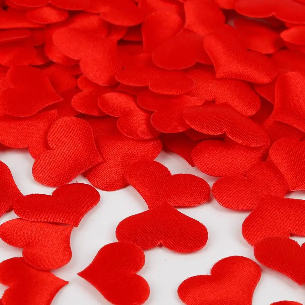 Red heart-shaped sponge confetti scattered on a white surface for weddings and celebrations