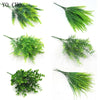 Various sprigs of artificial green ferns and leaves used for floral or botanical decoration