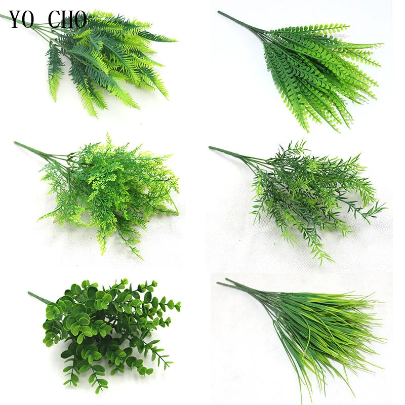 Various sprigs of artificial green ferns and leaves used for floral or botanical decoration