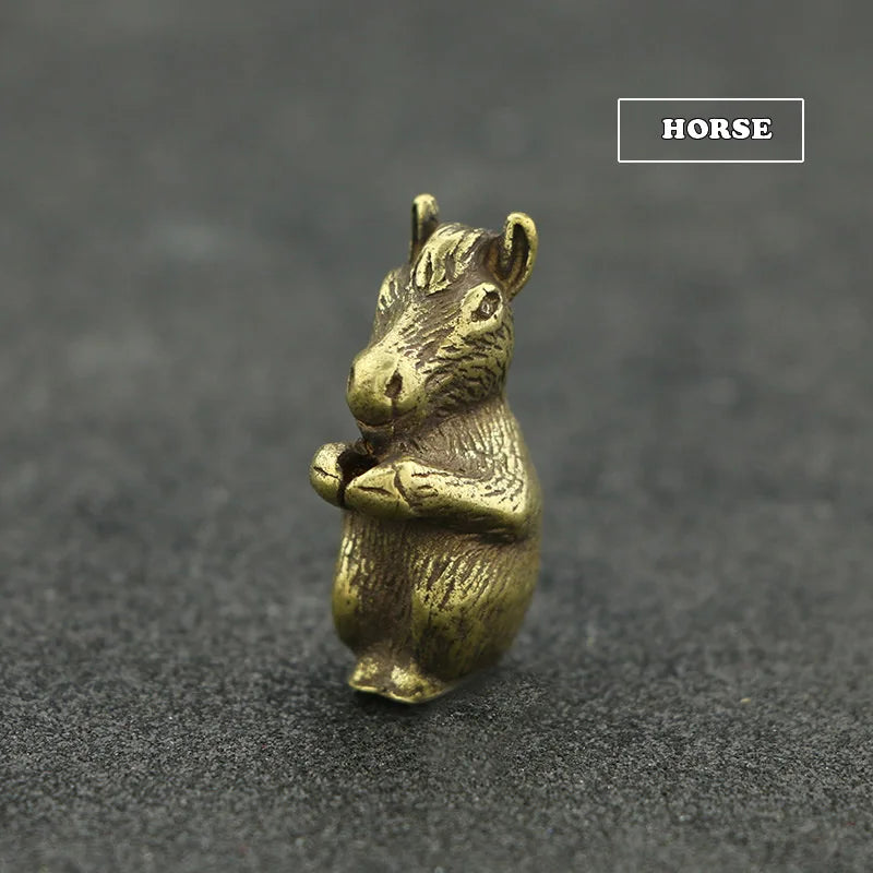 A small brass statue of a horse with its front legs folded, used as an incense holder.