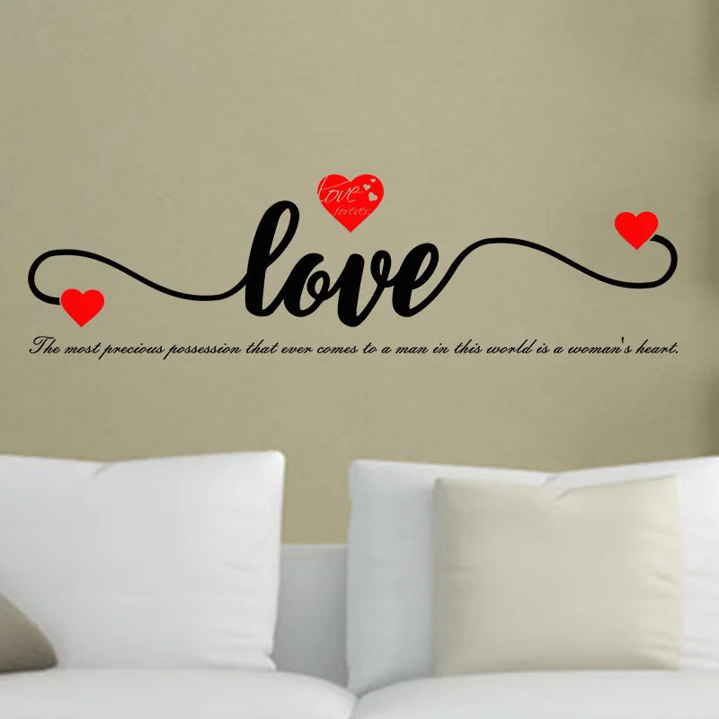 A black script word love with red hearts above it on a beige wall.