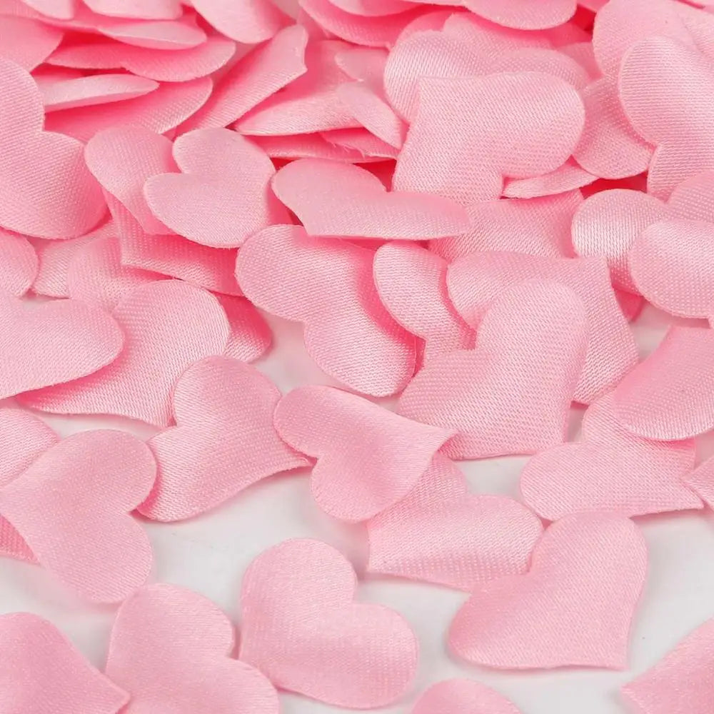 Pink heart-shaped sponge confetti scattered on a white surface for weddings and celebrations