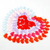 A heart-shaped confetti display in various pastel and bright red colors arranged in a heart shape.