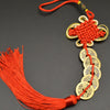 A handwoven knot charm featuring an I Ching copper coin and Feng Shui design, tied with a red thread.