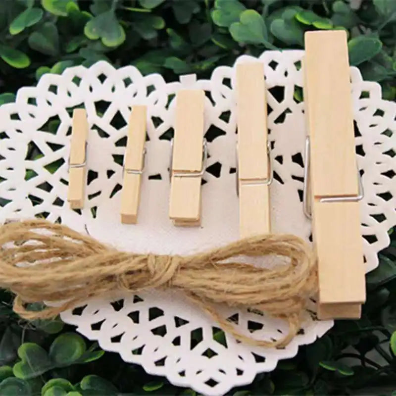 A set of natural wooden clips used for crafts, photos, and decor, laid on a white lace doily.