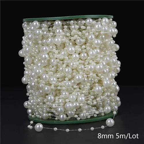 A spool of ivory pearl beads used for garland decoration, with a string of beads visible below.
