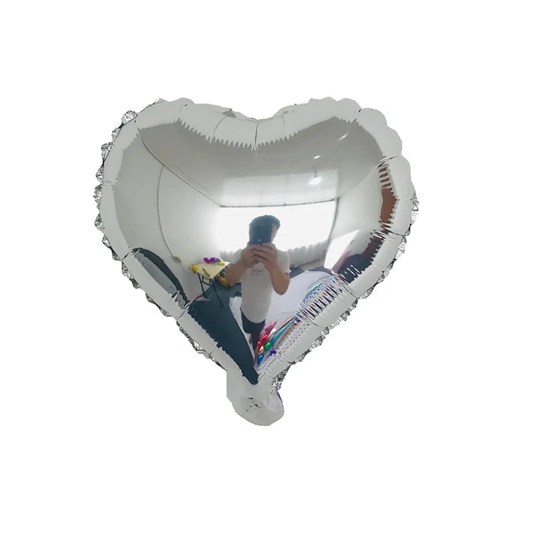 Eine Person ist in einem großen herzförmigen Aluminiumfolienballon und schaut durch die transparente Oberfläche.