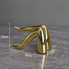 Gold faux finish human body resin art sculpture in a stylized, elongated form.