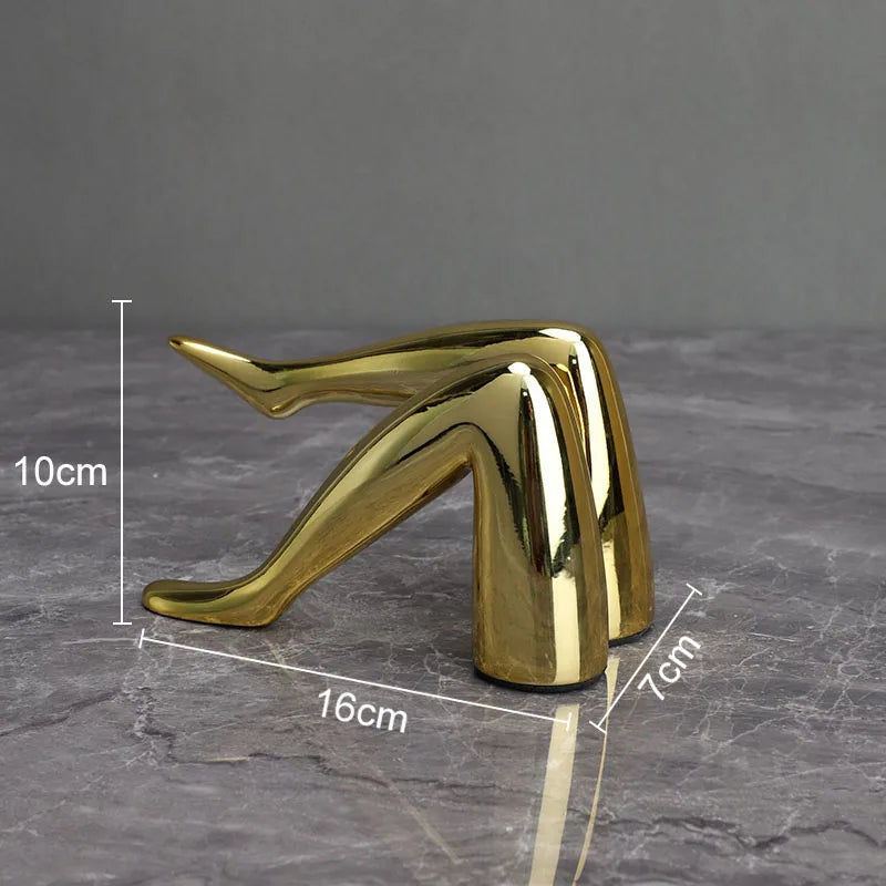 Gold faux finish human body resin art sculpture in a stylized, elongated form.