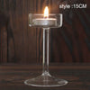 Elegant clear glass candle holder with a lit candle on a wooden surface.