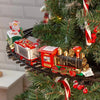 A red battery-powered railway train toy with gold accents is displayed on a Christmas tree.