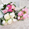 A bouquet of pink and white silk rose and peony artificial flowers with green leaves