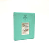 A teal rectangular photo album titled Pieces of Moment with a small illustration on the front.