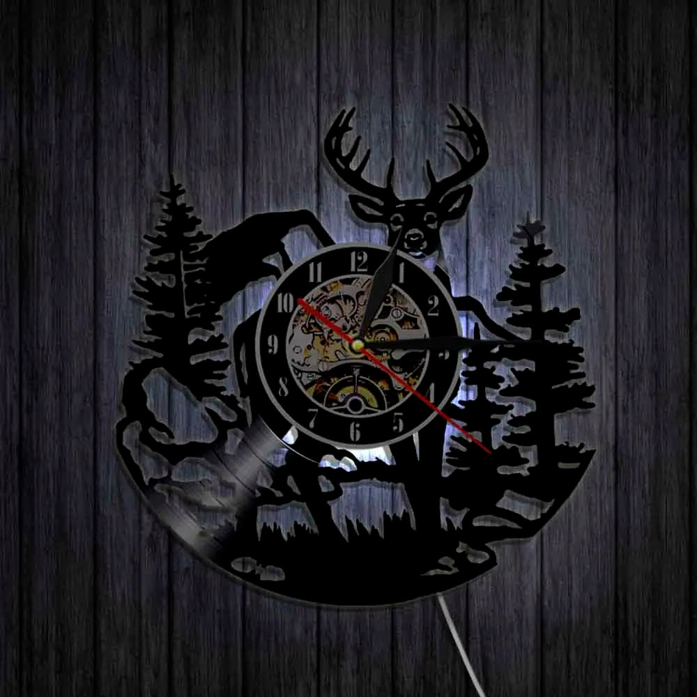 A black silhouette of a woodland elk deer head is cut into a round clock face with a dark background.