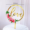 Rose gold acrylic love heart cake topper with pink roses on a white cake.