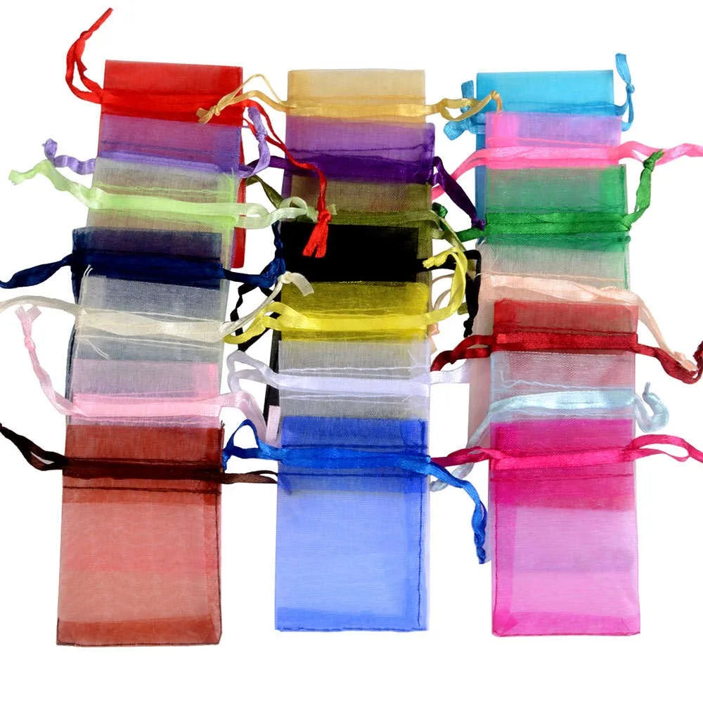 A colorful stack of organza drawstring gift pouches in various shades of pink, purple, blue, green, and red.