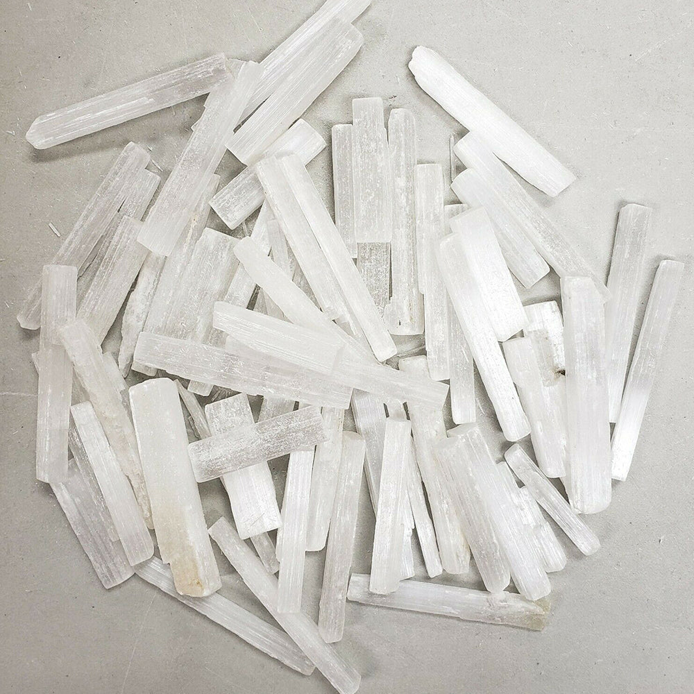 A collection of clear, translucent natural selenite crystal wands for healing and crafting.