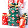 A collection of festive Christmas drawstring gift bags featuring snowflake and Santa designs in red, green, and gold.
