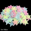 A collection of glow-in-the-dark star and moon wall stickers in various pastel colors like pink, yellow, and blue.