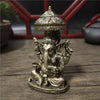 Bronze Ganesha Buddha statue with a dome top sitting on a wooden surface.