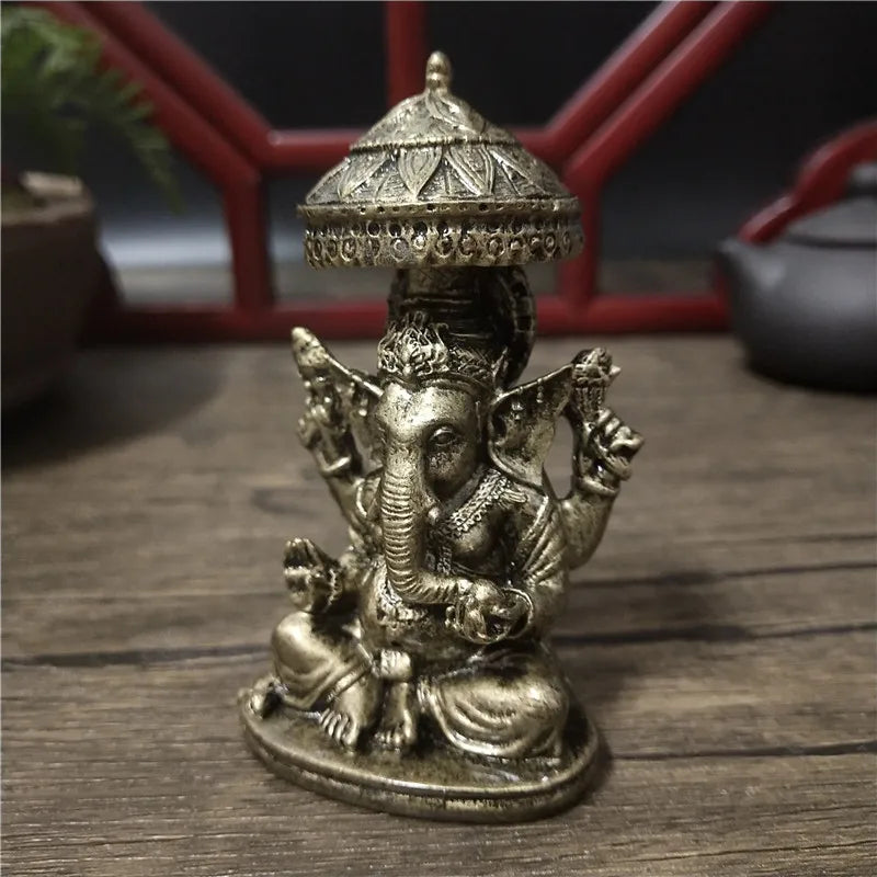 Bronze Ganesha Buddha statue with a dome top sitting on a wooden surface.