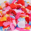 A colorful mix of silk rose petals in shades of pink, red, blue, and orange.