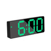 A black digital alarm clock displaying the time 6:00 in bright green LED digits.