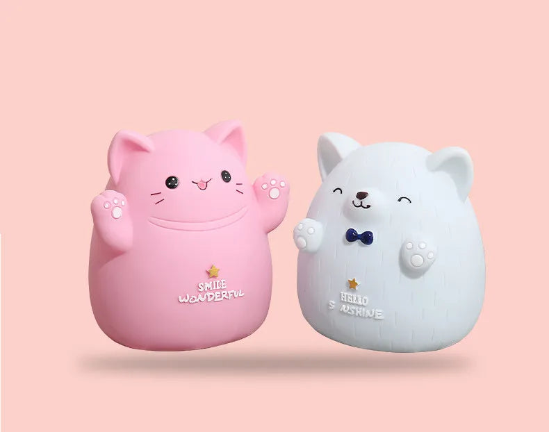 A pink cartoon cat figure and a white bear figure are displayed against a light background.