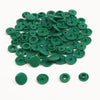 A pile of assorted green snap buttons, measuring 12mm and 10.5mm, for crafting.