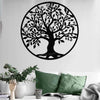 A black silhouette of a tree with many leaves is mounted on a white wall above a sofa.