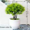 Artificial bonsai tree with bright green needles in a white pot, used as desk or home decor.