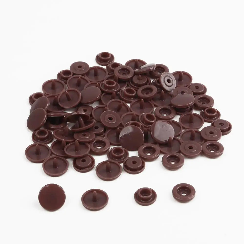 A pile of assorted dark brown snap buttons, measuring 12mm and 10.5mm, for crafting.