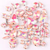 A mix of silver claw setting glass rhinestones in jelly candy AB colors scattered on a white background.