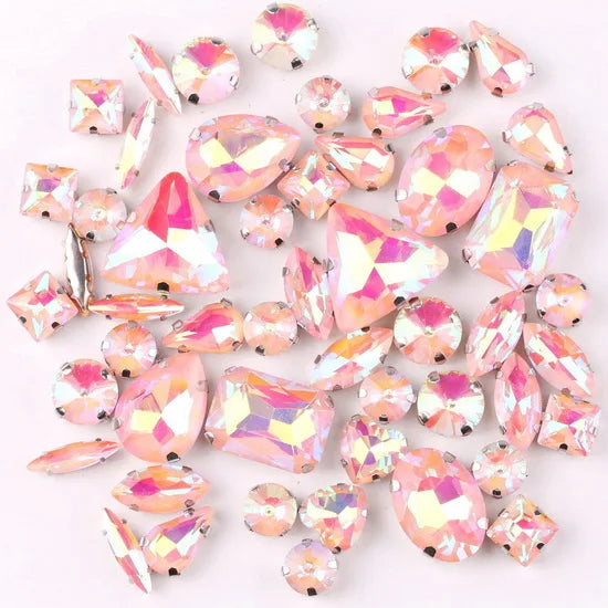 A mix of silver claw setting glass rhinestones in jelly candy AB colors scattered on a white background.