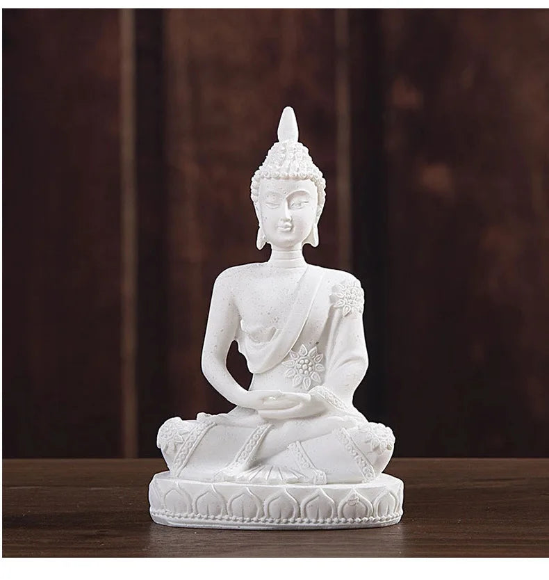 White resin Buddha statue with a serene expression seated in meditation on a round base.