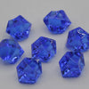 Several faceted blue acrylic crystals or decorations scattered on a white surface.
