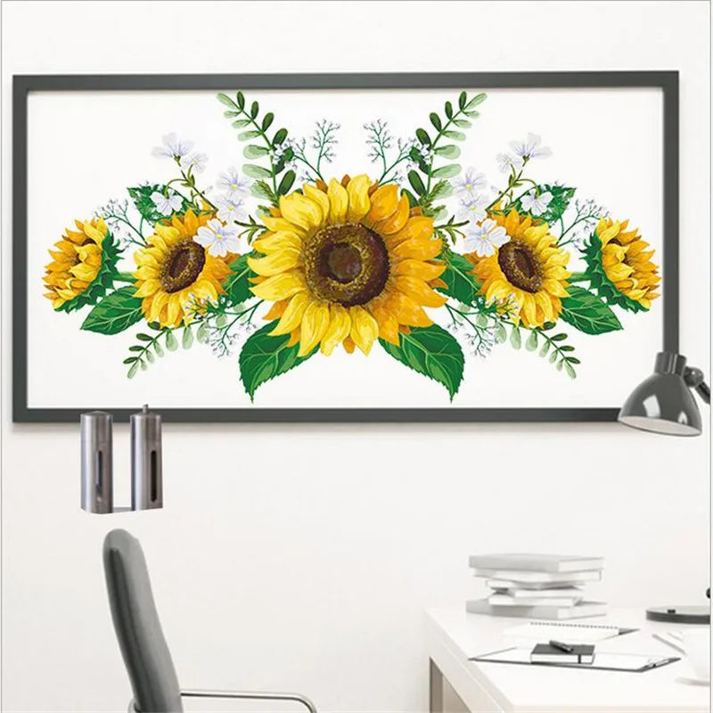 A framed floral print featuring yellow sunflowers and green foliage on a white background.