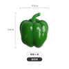 A green bell pepper shaped fridge magnet with a stem, shown against a white background.